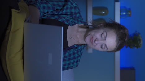 Vertikales-Video-Einer-Lachenden-Frau,-Die-Nachts-Einen-Laptop-Benutzt.